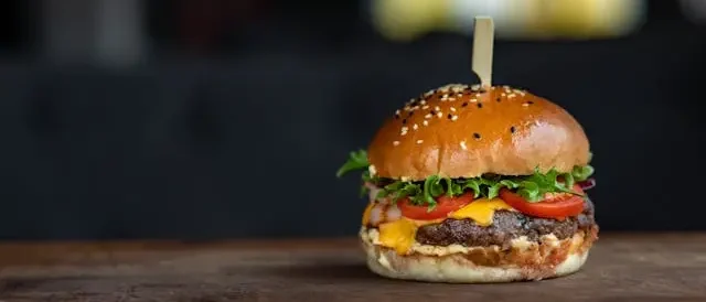 burger sitting on wooden table top